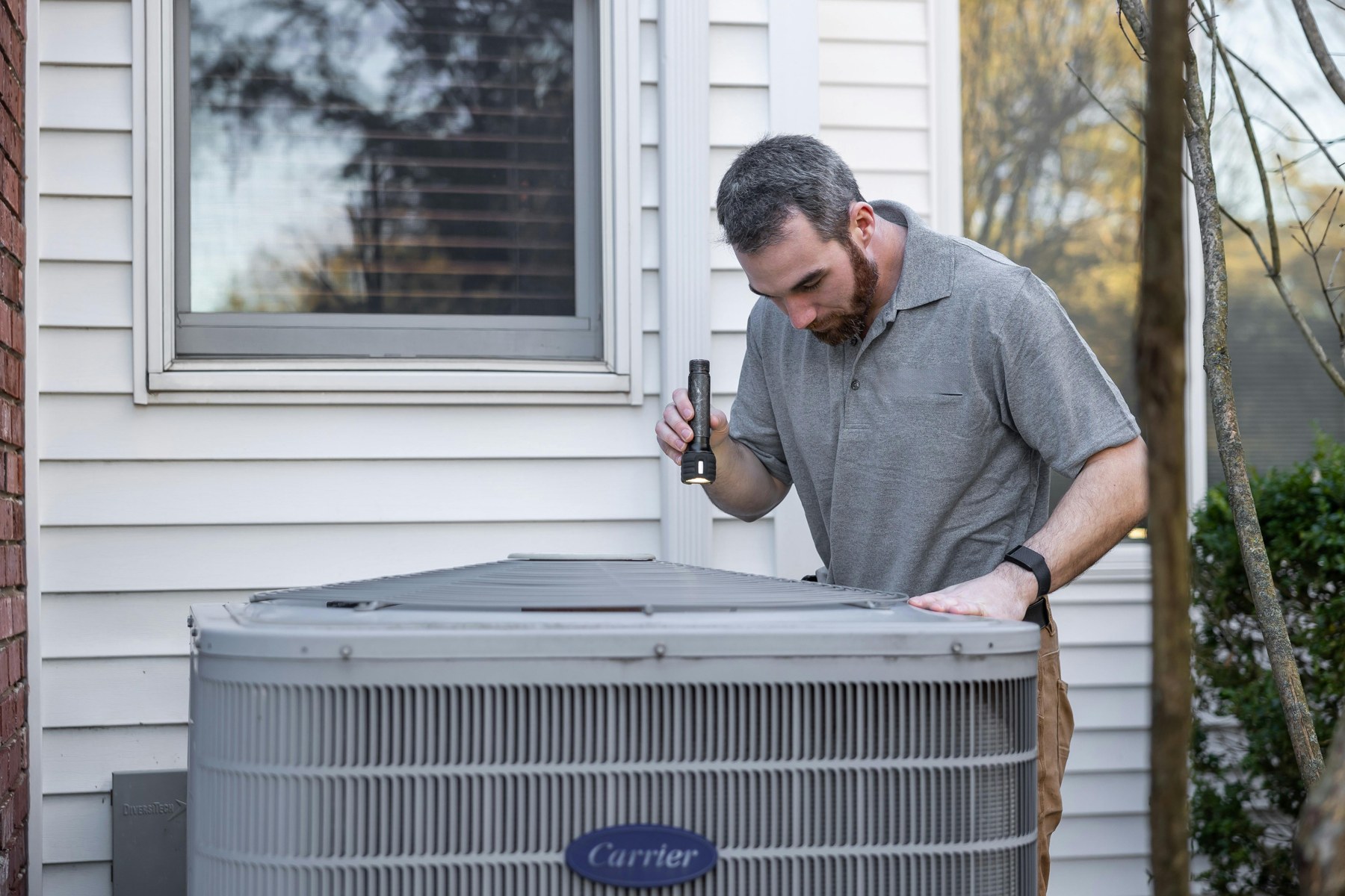 HVAC technician inspecting an outdoor unit